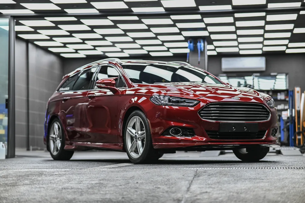 Ford Mondeo Wagon 紅色旅行車完成全車透明保護膜包覆後停於廠內，車身側面映出天花板棋盤格燈條｜誠美車體美容