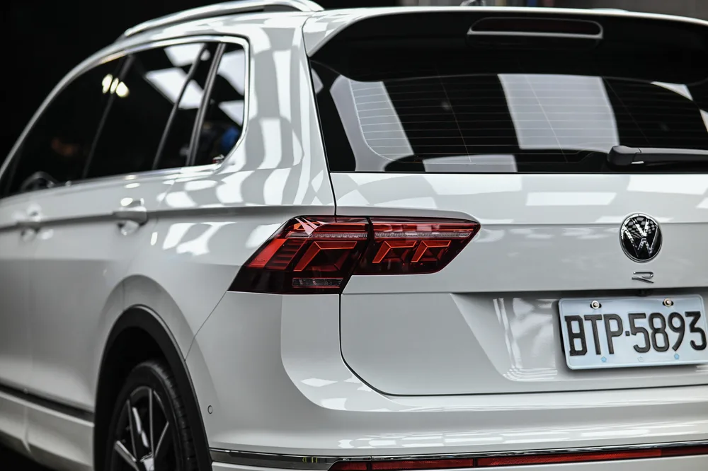 白色 Tiguan 後方四分之三視角，尾燈與車尾鈑件線條清晰