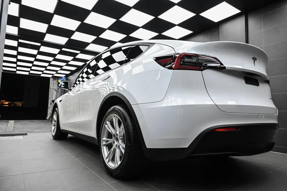 白色 Tesla Model Y 於施工棚內的左後四十五度全車樣貌