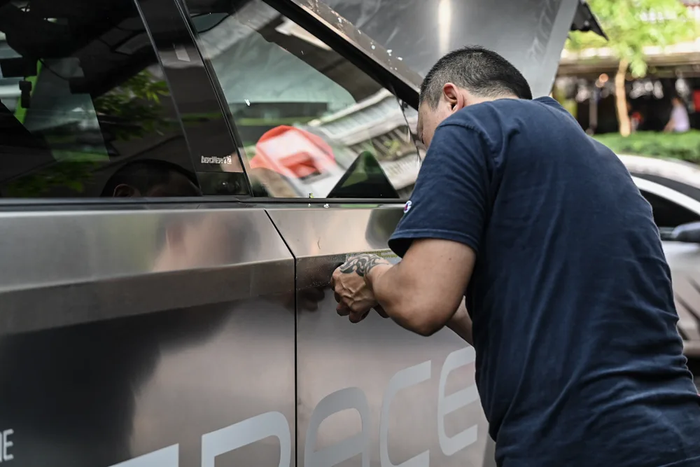 技師沿車門邊緣刮除貼膜與底層殘膠