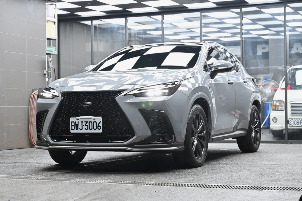 Lexus NX 350 淺灰車身在廠內完成膜料維護後的車頭四分之三視角，車頂棋盤格燈條完整映在引擎蓋上｜誠美車體美容