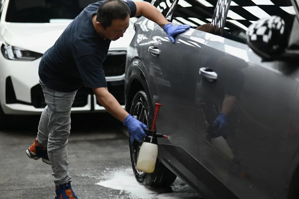 技師以泡沫清洗車側與輪圈，完成施工前的前置清潔