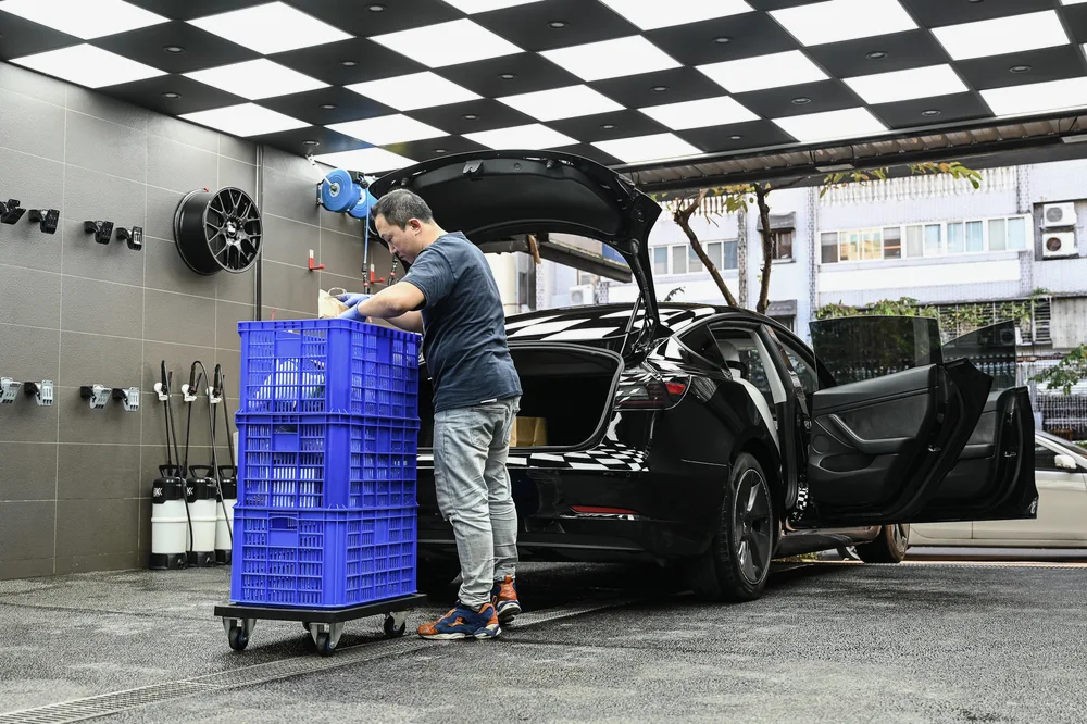 施工人員將整箱作業用品推到掀起的後行李廂旁準備開工