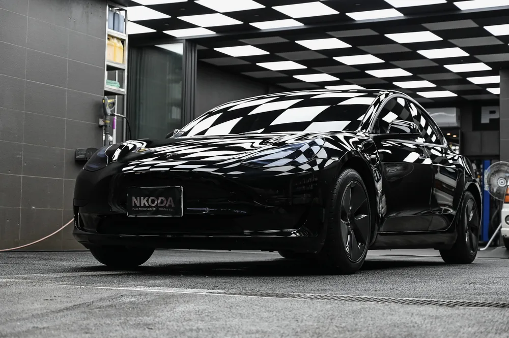 黑色 Tesla Model 3 左後四十五度的整體車身反射