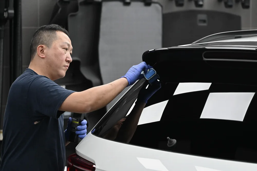 技師處理後方車窗玻璃的鍍膜塗佈