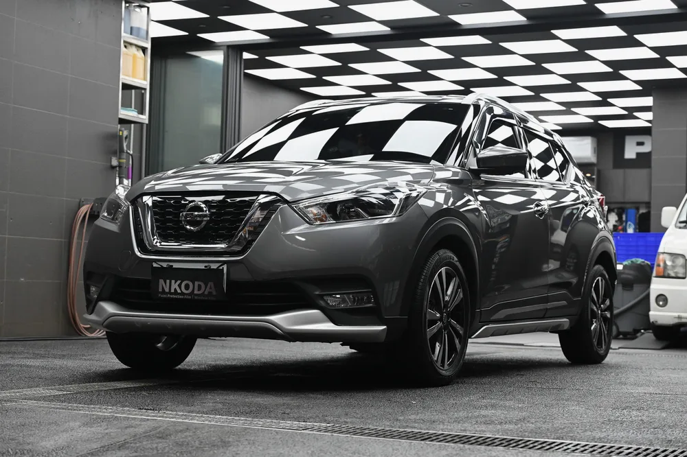 深灰色 Nissan Kicks 完成日本 3D 滑水精緻護理後停於格紋施工區，右前方全景，誠美車體美容